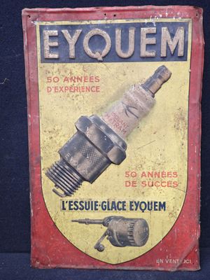 une vieille enseigne en tôle sur laquelle figure l'image d'une étincelle