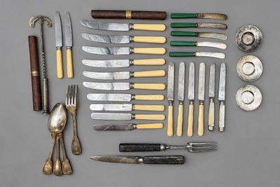 de nombreux types de couteaux et de cuillères disposés sur une table