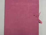 a pink book with a pink ribbon tied to it