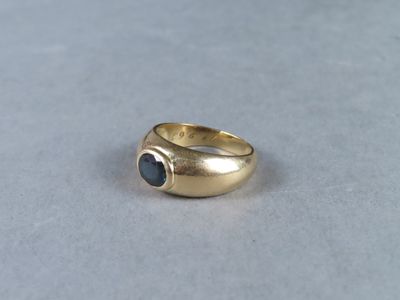 gros plan d'une bague en or avec une pierre noire