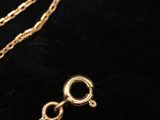 a close up of a gold chain on a black surface