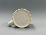 a close up of a cup on a table with a gray background