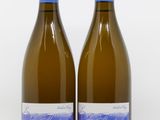 two bottles of white wine sitting next to each other on a white surface