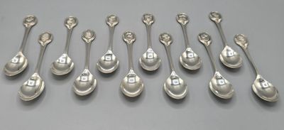 six cuillères en argent sont alignées sur une table