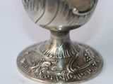 a silver cup that is sitting on a white table