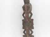 une image représentant une sculpture en bois d'une personne tenant un couteau