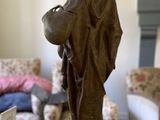 a statue of a man holding a basket on a table