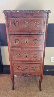 a tall wooden chest of drawers on a carpeted floor