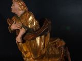 statue of a woman sitting on a chair with her arms crossed