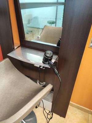 a hair dryer sitting on a chair in front of a mirror