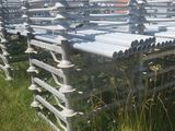 many rows of metal benches in the grass near a building