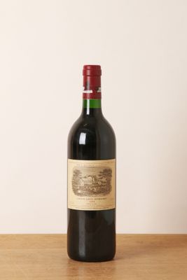 une bouteille de vin rouge posée sur une table en bois
