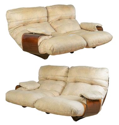 pair of cream colored reclining chairs with wooden arms and foot rests