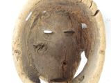 a wooden mask with a hole in the middle of it