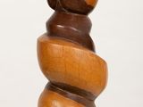 a wooden sculpture of a bear sitting on top of a stack of rocks