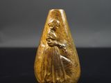 une image représentant une figurine en or posée sur une surface noire