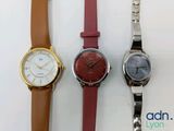 three different colored watches sitting next to each other on a white surface