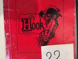 un livre rouge sur lequel figure l'image d'un homme à moto