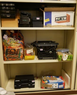 une étagère sur laquelle se trouvent une machine à écrire, une imprimante et d'autres objets
