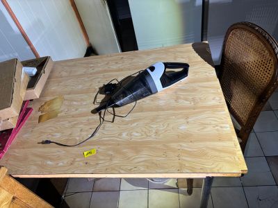 a small table with a vacuum on it and a chair
