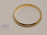 gros plan d'une bague en or sur une surface blanche