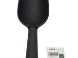 une photo d'une brosse à cheveux noire avec une étiquette dessus