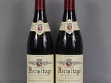 deux bouteilles de vin rouge posées sur une table en verre