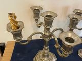 a silver candelab with five candles on a blue table