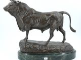 statue of a bull standing on a rock on a white background