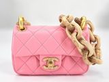 un petit sac à main rose muni d'une chaîne dorée