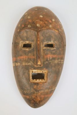 un vieux masque en bois accroché à un mur blanc, sur fond blanc