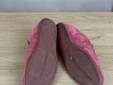 a pair of pink shoes sitting on top of a wooden table