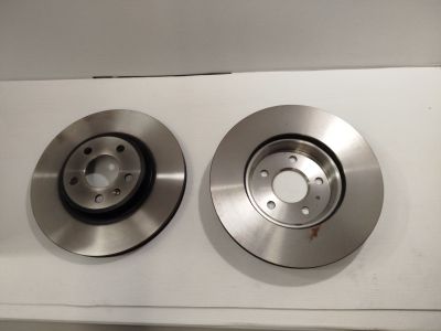 un gros plan de deux disques de frein sur une surface blanche