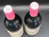 deux bouteilles de vin posées sur une table l'une à côté de l'autre