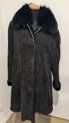 une photo d'un manteau noir à col de fourrure posé sur un mannequin
