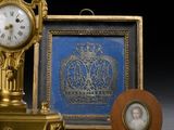 une horloge en or posée à côté d'une photo d'une femme