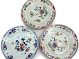 three plates with floral designs on them on a white surface