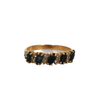 a close up of a gold ring with blue stones