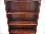 an old wooden bookcase with three shelves on top of it