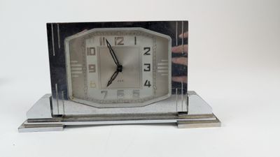 une horloge en argent posée sur une table