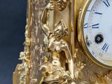 a gold clock that is sitting on top of a table