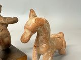 two figurines of a horse and a dog on a white surface