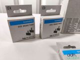 three boxes of disc brake pads sitting on a table next to a pair of scissors