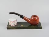 une image représentant une pipe et une pile de livres posés sur une table