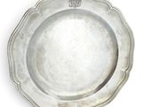 an antique silver plate on a white background with a crown on it