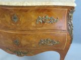 a marble top chest of drawers on a stand