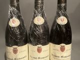 three bottles of wine wrapped in plastic sitting on a table