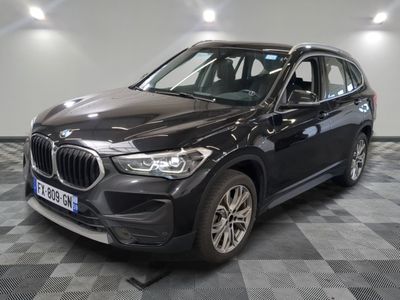 La BMW X1 est garée dans un showroom dont le sol est en damier.