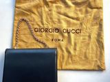 the black bag is next to the black purse on the table