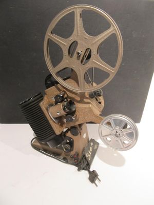 un vieux projecteur de cinéma posé sur une table à côté d'un appareil photo